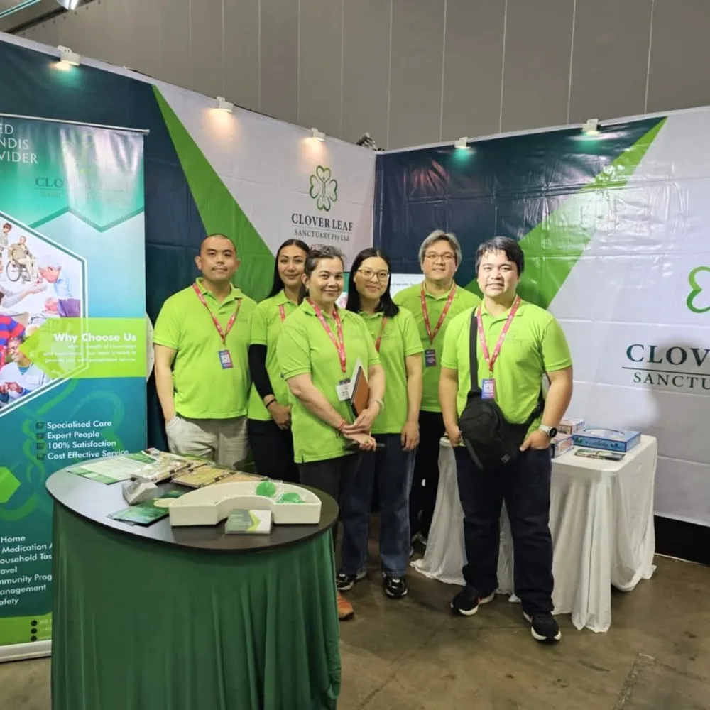 The Clover Leaf Sanctuary team in branded green polo shirts at their booth at a 2024 NDIS provider expo