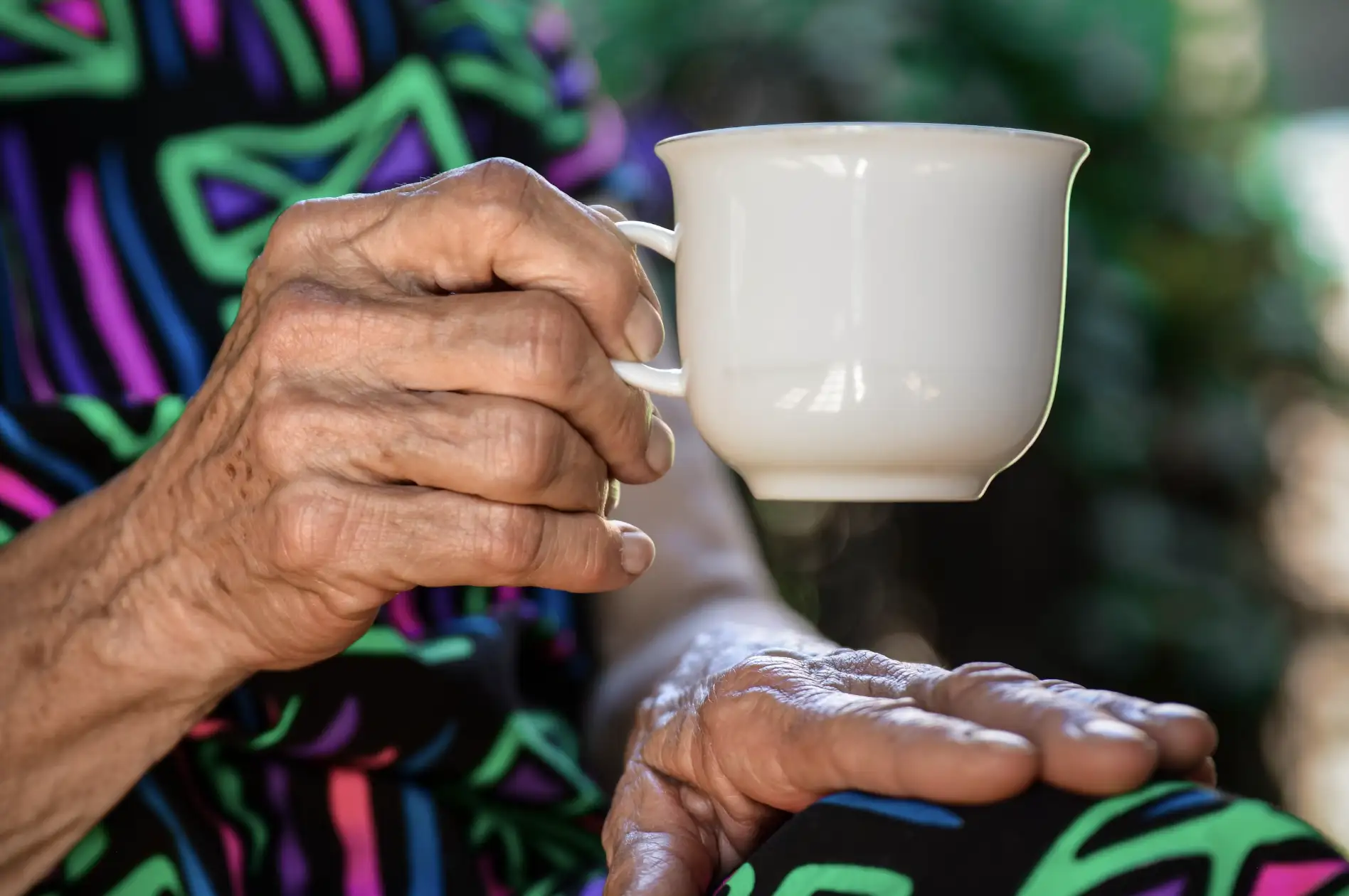 A carer and client enjoy a cup of tea together.