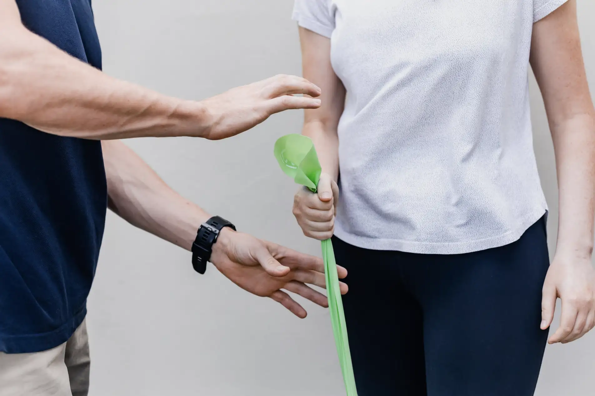 A physiotherapist assists a client with exercises at home.